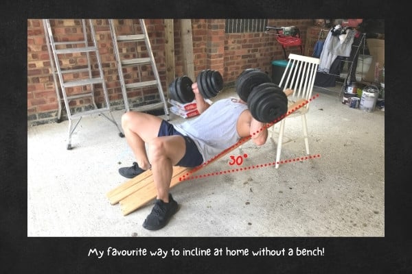 Mimic an incline bench at home using a chair and bed slats.