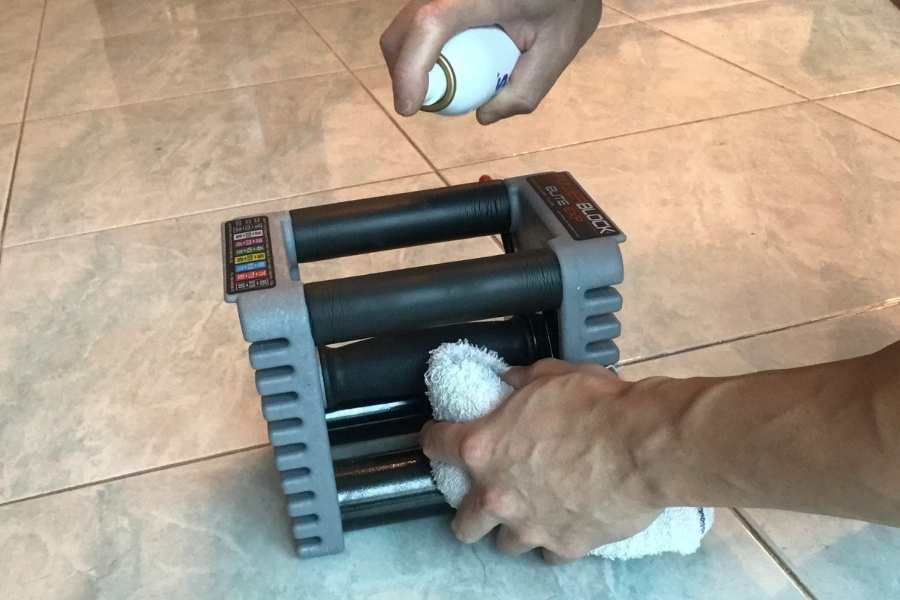 How to clean the PowerBlock handle with disinfectant spray.