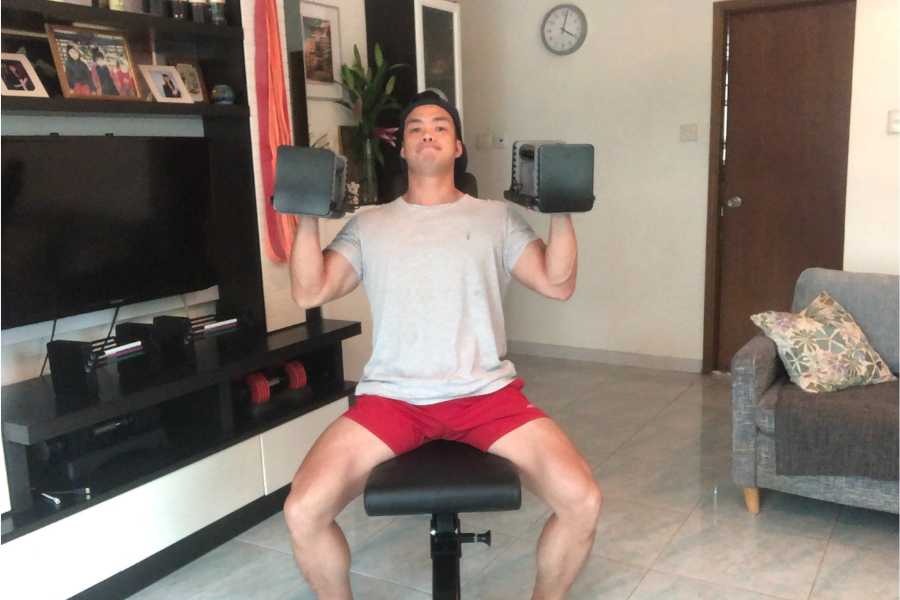 Use a weight bench to keep your back straight in the seated dumbbell shoulder press.